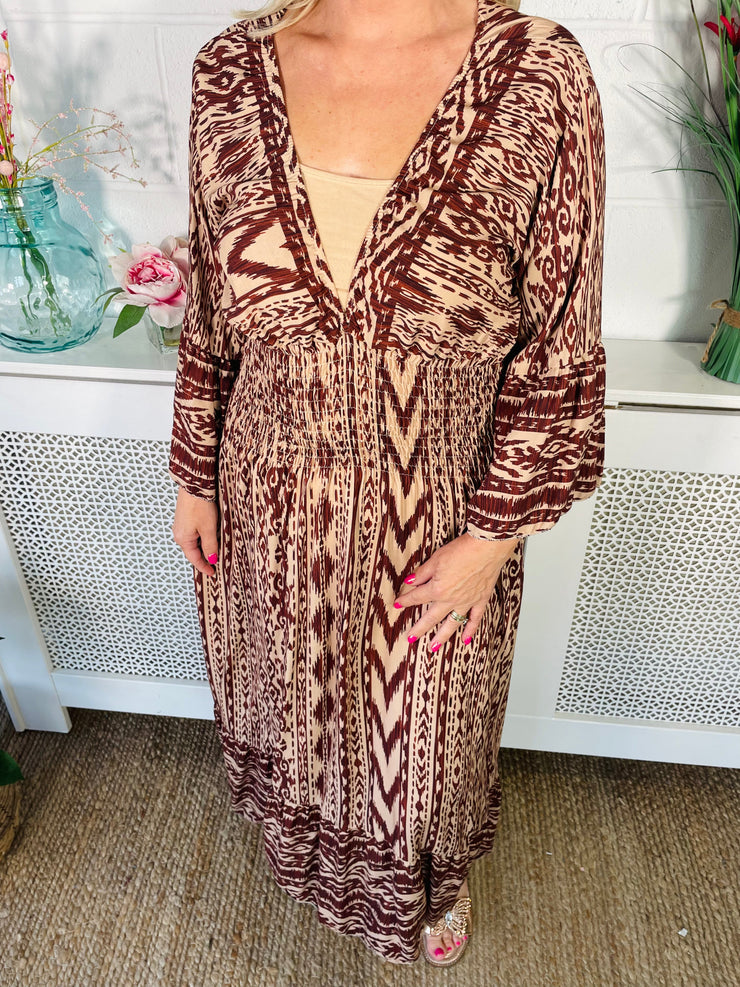 Close up of Tan patterned midi dress with v neckline and floaty sleeves